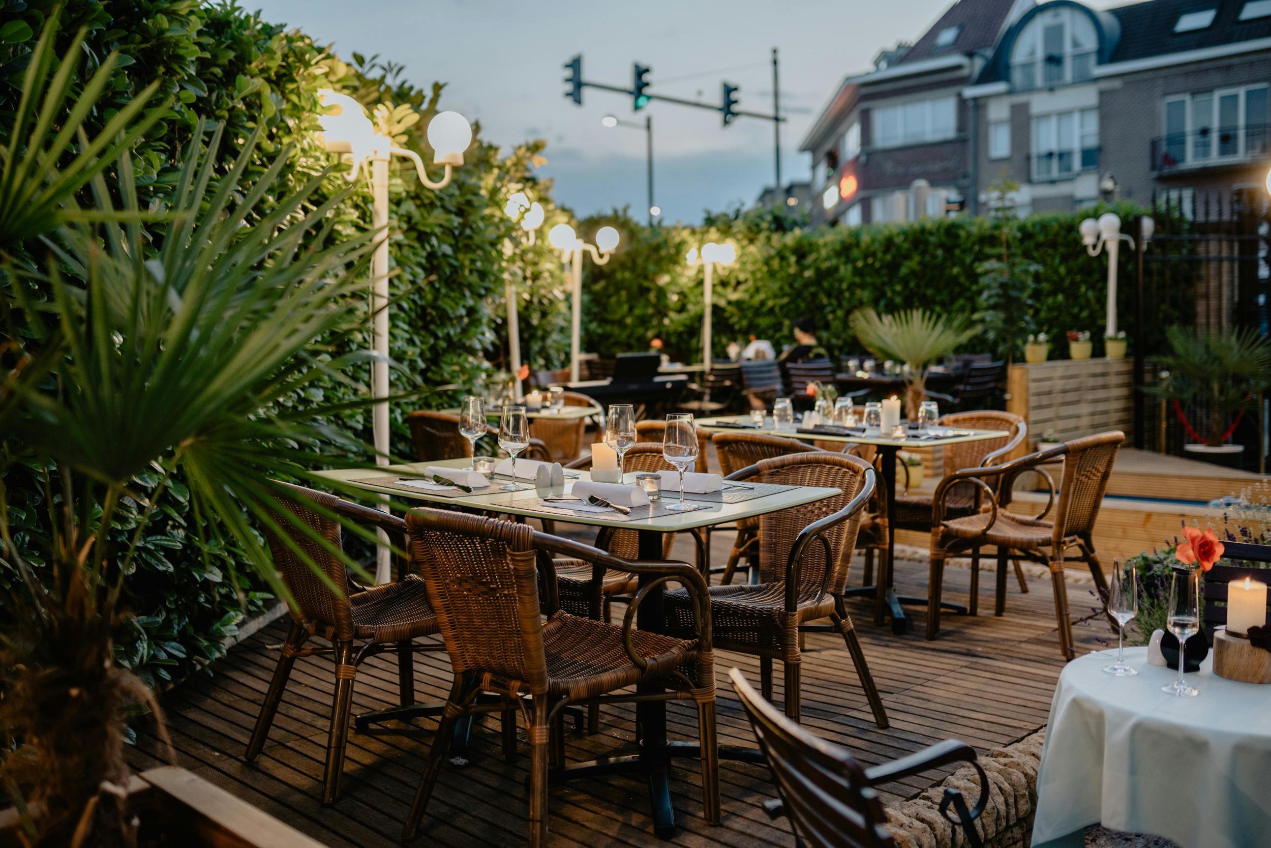 Cozy outdoor restaurant terrace with ambient lighting and elegant table setup.